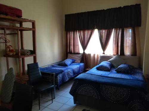 a bedroom with two beds and a window at Mac Malone's in Nelspruit