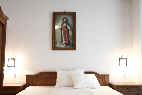 1 dormitorio con 1 cama con una foto en la pared en Mellis 1, en Cluj-Napoca