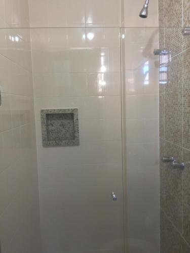 a shower with a glass door in a bathroom at Colle Tourist Hotel LUXO in Criciúma