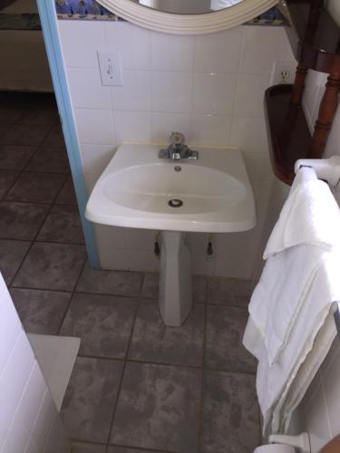 a bathroom with a white sink and a toilet at Graham's Place in Guanaja