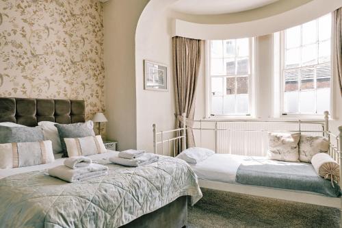 a bedroom with two beds and a window at The Queens Hotel in Lytham St Annes