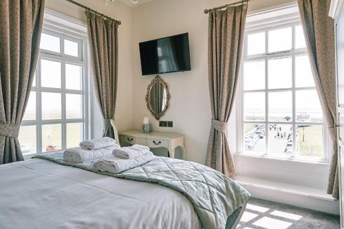 a bedroom with a bed with towels on it at The Queens Hotel in Lytham St Annes