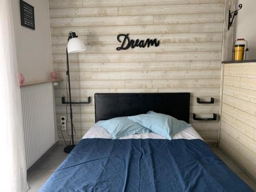 ein Schlafzimmer mit einem Bett und einem Schild an der Wand in der Unterkunft Gite les Combes Terrasse 01340 ETREZ in Étrez