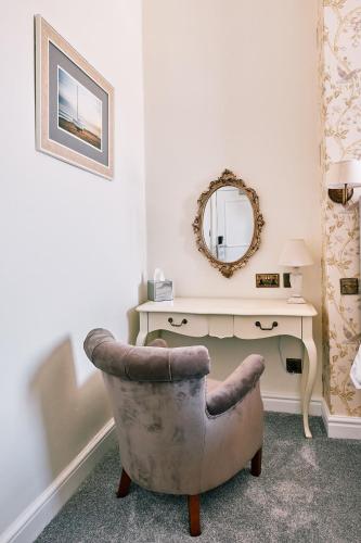 a room with a desk and a chair and a mirror at The Queens Hotel in Lytham St Annes