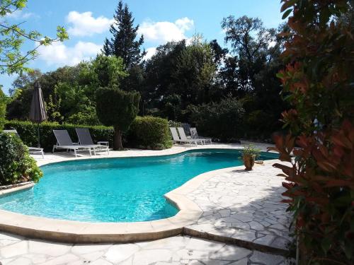 - une piscine dans une cour avec des chaises et des arbres dans l'établissement Villa Souleiadito dans le Golfe de Saint Tropez, au Plan-de-la-Tour