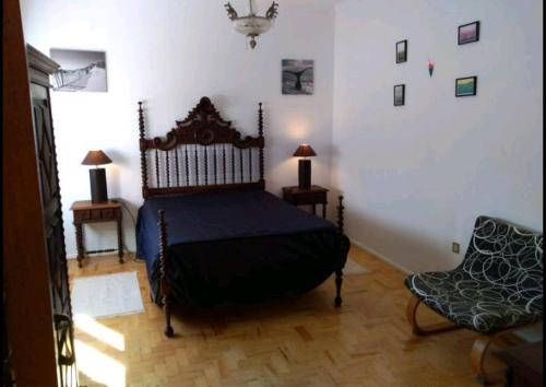 1 dormitorio con 1 cama, 2 mesas y 1 silla en Beach house with garden, en Sintra