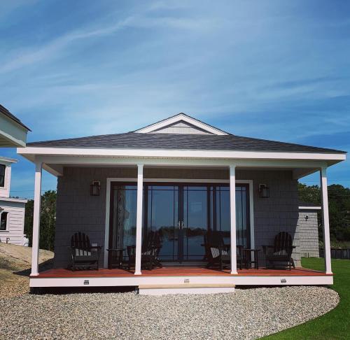 a house with a screened in porch with chairs at Harbor View Landing in Mystic