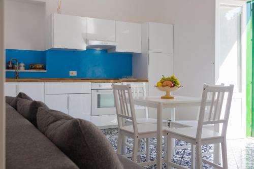 a kitchen with white cabinets and a white table and chairs at Villa Mallandrino in Mondello