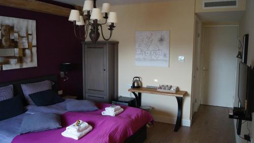 a bedroom with two beds and a table with towels at B&B Johannes-Hoeve in Baarlo