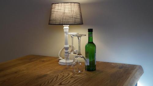 a bottle of wine sitting on a table next to a lamp at B&B Johannes-Hoeve in Baarlo