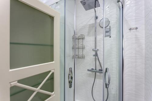 um chuveiro com uma porta de vidro na casa de banho em Lux Apartments In The Center em Lviv