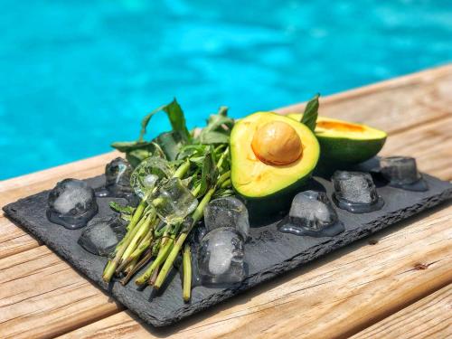 a black plate with an avocado and vegetables on a table at HMA Hotel & Suites in Alanya