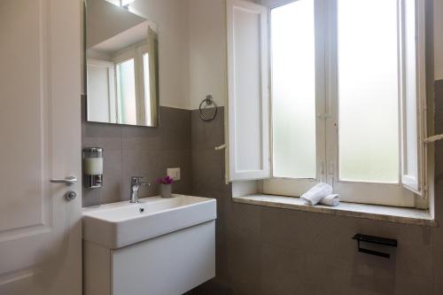 a bathroom with a white sink and a window at Villa Mallandrino in Mondello