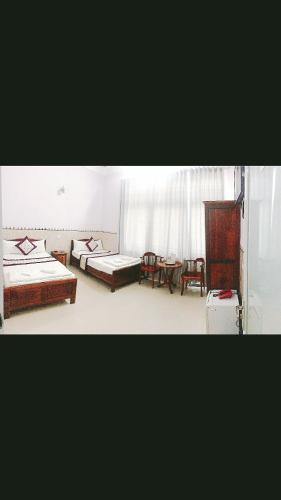 Zimmer mit 2 Betten und einem Tisch in der Unterkunft Minh Minh Hotel in Quy Nhon