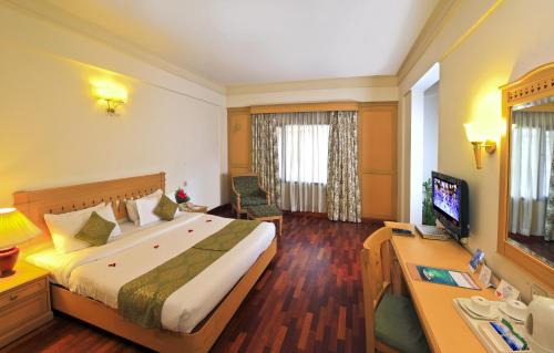 a hotel room with a bed and a desk at Abad Atrium in Cochin