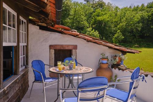 a patio with a table and chairs and a fireplace at A Charming , Traditional Cottage at Quinta da Ribeira in Vila Nova de Poiares