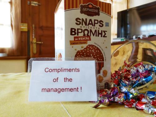a sign on a table with a box of bread and some candy at Kalokenti Studios in Aegina Town