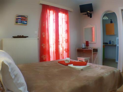 a bedroom with a bed with a red curtain at Kalokenti Studios in Aegina Town