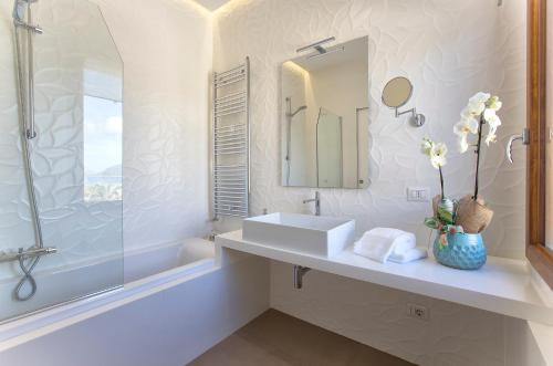 a white bathroom with a sink and a mirror at LA CASA DI IRENE in Alghero