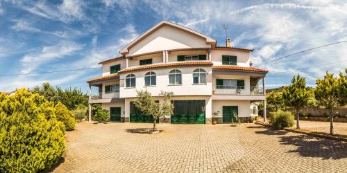 a large white house with a driveway in front of it at Casa do Luzio in Macedo de Cavaleiros