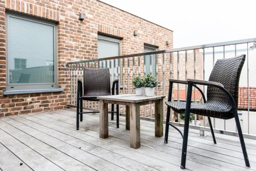 two chairs and a table on a balcony at Maison de la Paix in Poperinge