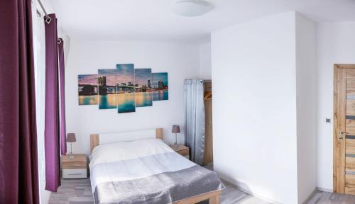 1 dormitorio con 1 cama y una pintura en la pared en Dovolenkový dom Active & Relax, en Veľká Lomnica