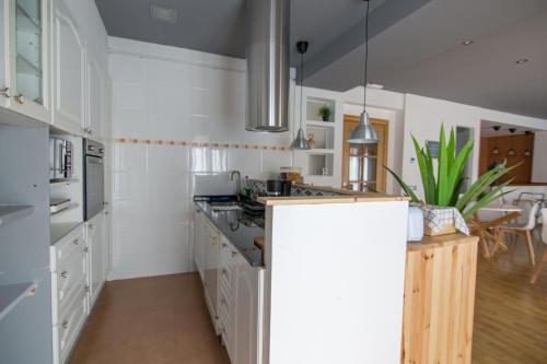 a kitchen with white cabinets and a dining room at Tinto Dreams Hostel in Haro