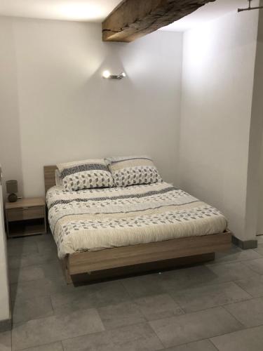Ce lit se trouve dans un dortoir doté d'un mur blanc. dans l'établissement Appartement spacieux, chaleureux 39 m², à Lagnieu