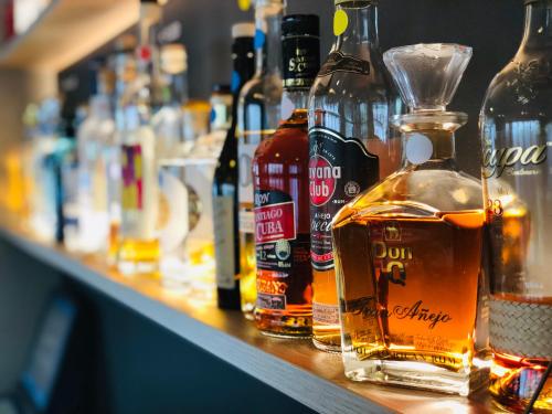 a row of bottles of alcohol sitting on a bar at Hotel Felmis in Luzern