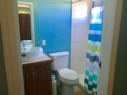 a bathroom with a white toilet and a sink at Tilt-Ta-Dock Resort Belize in Corozal