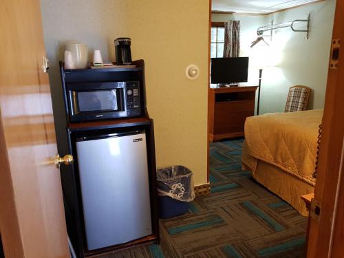 a hotel room with a microwave on top of a refrigerator at Franconia Notch Motel in Lincoln