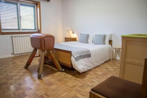a bedroom with a bed and a chair in it at Casa do Luzio in Macedo de Cavaleiros
