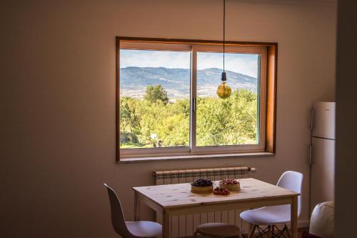 a table and a window with a table and chairs at Casa do Luzio in Macedo de Cavaleiros