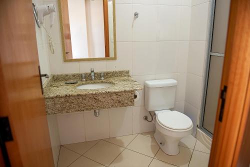 a bathroom with a toilet and a sink and a mirror at Hotel Prata Villaggio in Nova Prata