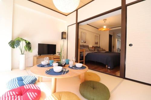 a living room with a table and chairs and a bedroom at Osaka Mainichi Building Vacation STAY 242 in Osaka