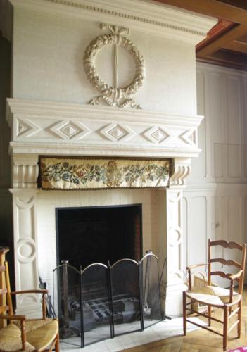 a living room with a fireplace with a wreath above it at Le Rossay in Saint-Clément-de-la-Place