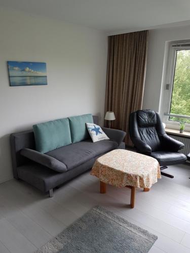 a living room with a couch and two chairs at Ferienwohnung Strandliebe in Glücksburg