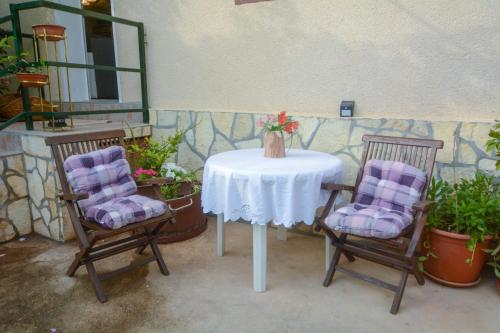 una mesa con dos sillas y un jarrón en ella en Apartments Martinović, en Zaton