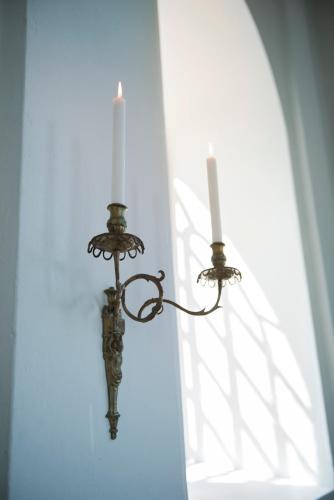 a candle holder with two candles on a wall at Mauritzbergs Slott & Golf in Mauritsberg