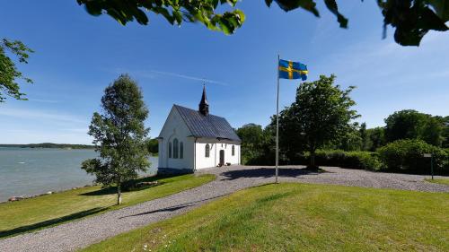 a church with a flag in front of the water at Mauritzbergs Slott & Golf in Mauritsberg