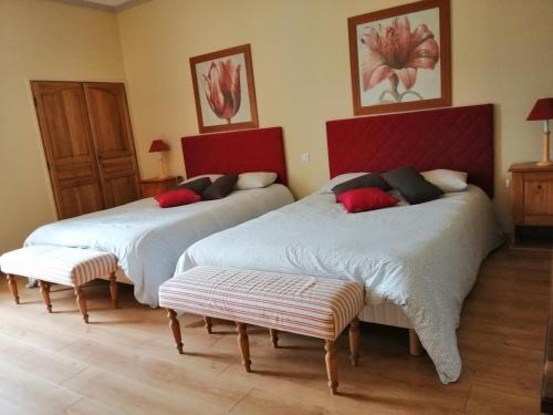 two beds in a room with two ottomans at Chambres d´Hôtes Le Cèdre Bleu in Saint-Lattier