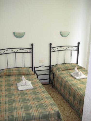 two beds with towels on them in a room at Bungalows Boston in Puerto Rico de Gran Canaria