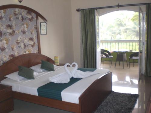 Un dormitorio con una cama con cisnes. en A's Holiday Beach Resort en Betalbatim