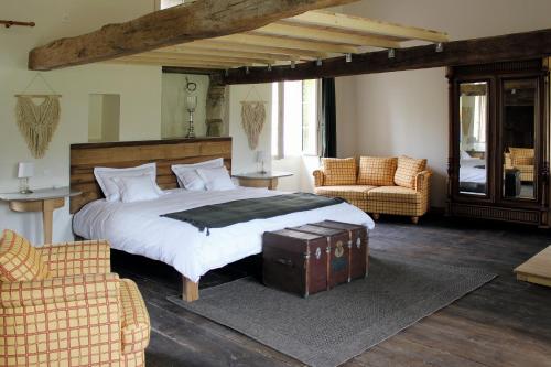 - une chambre avec un grand lit et deux chaises dans l'établissement Gite La Grange de Jeanne, à Rancon