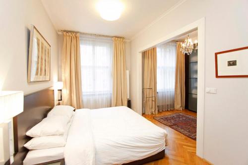 プラハにあるSpacious elegance in the heart of Old Townのベッドルーム(白いベッド1台、大きな窓付)