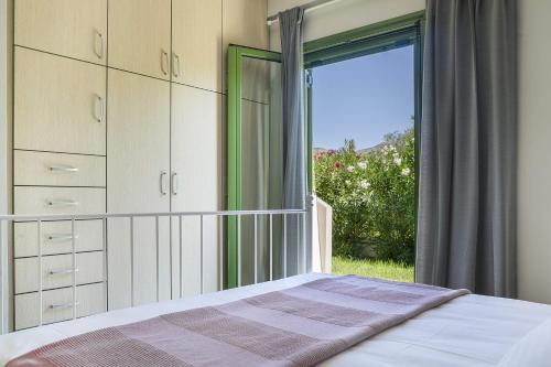 a bedroom with a bed and a large window at Earth Apartment in Katelios