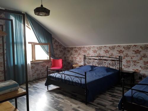 um quarto com uma cama e uma cadeira vermelha em Kobuleti em Kobuleti