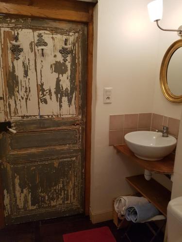 an old door in a bathroom with a sink at Le Nid des Oiseaux in Cubjac