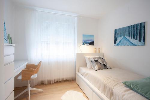 - une chambre avec un lit, un bureau et une fenêtre dans l'établissement Apartment Galerija Bled, à Bled