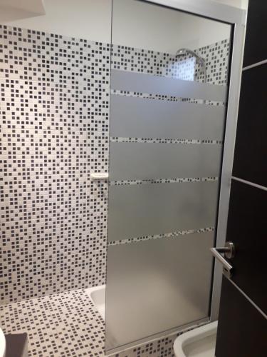 a shower with a glass door in a bathroom at Departamento Torre Sofitel in Río Cuarto